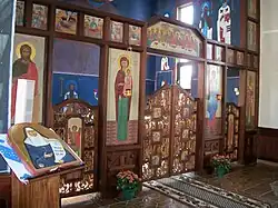 La cloison basse de l'iconostase, au premier plan à gauche, une icône d'une sainte avec sa relique.