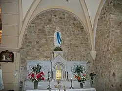 Autel et tabernacle en marbre surmontés d'une statue de Notre-Dame de Lourdes