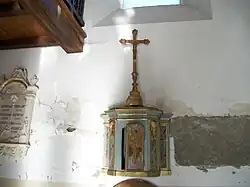 Tabernacle en bois avec des décors dorés, il est surmonté d'un crucifix