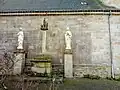 Façade nord de l'église avec les statues de la Vierge et de saint Jean encadrant un calvaire.