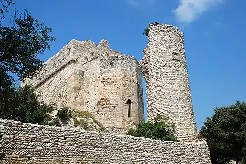Le chevet et la tour ; à l'avant-plan, un mur portant des traces d'appareil en arête-de-poisson.