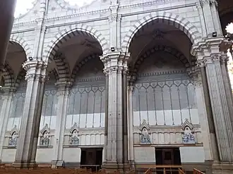 Photographie couleur latérale des arcs séparant la nef centrale des bas-côtés d'une église.