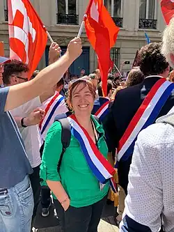 Élise Leboucher portant son écharpe de députée lors d'une manifestation.