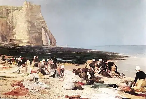 Un groupe de femmes s'activent sur une plage de la côte normande à marée basse et lavent du linge dans ces vasques naturelles.