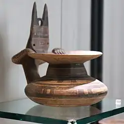 Œnochoé indigène (Iapyges, Daunie, 550-500) à l'animal stylisé, cornu, les mains sur le rebord et décor géométrique.