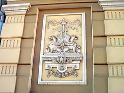 Écusson Héraldique de Lev figurant sur sa maison : Griffon modifié avec corps de lion évoquant son prénom et tête de dragon évoquant sa ténacité.