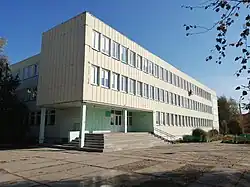 Photographie en contre-plongée d'un bâtiment blanc de style moderne en préfabriqué avec deux étages.