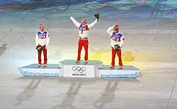 Vue de loin du podium des 50 kilomètres des Jeux de Sotchi, le vainqueur levant les bras en l'air.