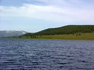 le lac avec une forêt et la chaîne d'Aigoulak au fond.