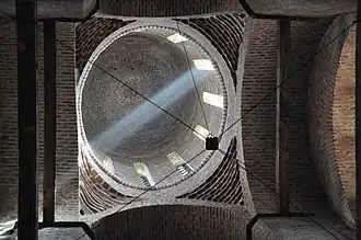 Vue en contre-plongée de la coupole de l'église, avec des rayons de lumières pénétrant par les fenêtres