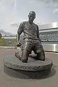 Statue de Thierry Henry célébrant un but devant l'Emirates Stadium.