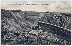 photographie en noir et blanc montrant des ruines desquelles émergent des fragments de métal épars.