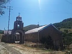 Vue de profil d'un animal aux longs poils collés, dont émerge une longue queue d'un côté, et un museau allongé de l'autre.