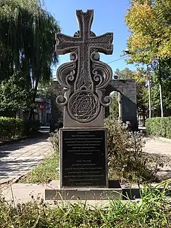 Photographie d'une pierre à croix (sculpture représentant une croix) au sein d'un cimetière.