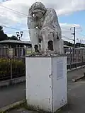Monument hommage Au voyageur méprisé inaugurée en 1990 devant la gare de Guipry-Messac, et représentant un voyageur accablé assis sur sa valise.