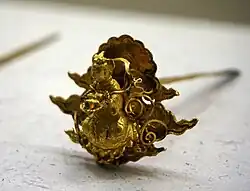 Épingle à cheveux représentant une figure du bouddhisme.