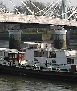 Une péniche passant en dessous d'un pont.