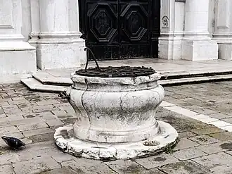 La tête de puits devant l'église