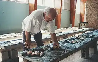 L'artiste Jocelyn Maltais plaçant des pierres peintes (alevins) dans un Tacon Caillou.