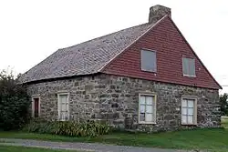 une maison en pierre avec un toit en bardeau de bois
