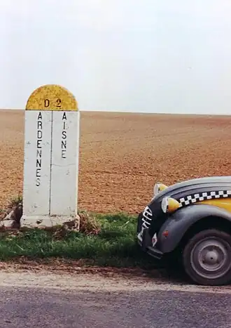 Borne en béton sur route départementale.