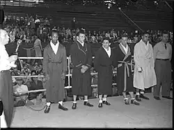 Des boxeurs en peignoirs se tiennent debout sur un ring de boxe.