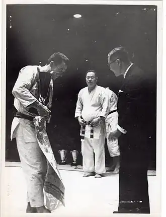 Mikinosuke Kawaishi, 10e&nbsp;dan (jū-dan, ceinture rouge). Au centre, en présence du champion d'Europe 1951, Jean de Herdt.