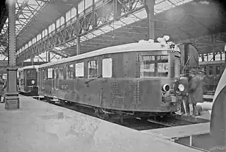 Photographie en sépia montrant une vue de trois quart avant d'une Pauline, caisse foncée et toit blanc.
