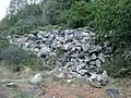 Blocs de kersantite (résidus de carrière) abandonnés le long du sentier piétonnier longeant la rive nord de la ria du Camfrout près de Kersanton.
