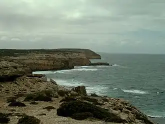 Vue distante de falaises avec la mer sur la droite