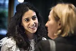 Toprak Yalçiner de face, souriant à une personne de trois quart dos