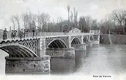 Photographie en noir et blanc d'un pont sur une rivière.