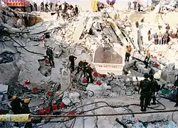 Secouristes opérant au milieu de décombres de dalles de béton.