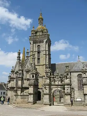 Enclos paroissial de Saint-Thégonnec, porte triomphale, ossuaire à gauche, clocher de l’église.