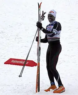 Philip Boit aux championnats du Monde à Oslo en 2001, debout dans la neige à côté de ses skis en tenue de compétition et avec un dossard