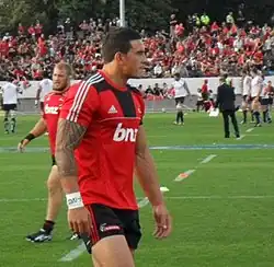Joueur de rugby marchant, vu de profil.