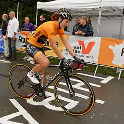 Photographie d'Elisa Longo Borgini, cycliste, en orange, vue de profil.