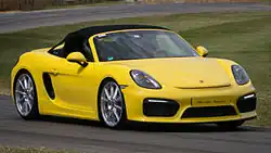 Photo d'un Boxster Spyder (981) jaune, en virage sur un circuit.