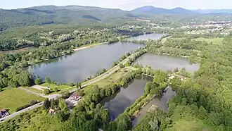 Les ballastières de Champagney surplombées par les Vosges dont la Planche des Belles Filles.