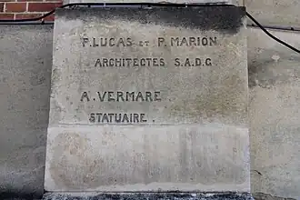 Épigraphe des architectes sur la façade de la salle des fêtes