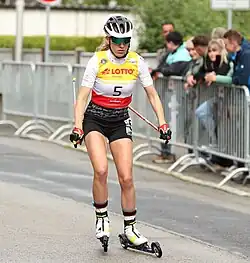 Une femme avec des lunettes de soleil faisant du rollerski.
