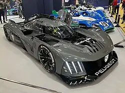 Photo du dessus d'une voiture de course grise et noire sur un stand d'exposition.