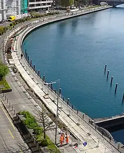 Quai du Rhône à Genève, rive droite, juste en amont du barrage du Seujet. Le Rhône est sur la droite de la photo. Sur la gauche, un quai sur lequel on voit des travaux d'enfouissement de conduites.