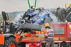 Photo de la voiture de Logan Sargeant chargée sur un remorqueur après son accident. Le capot moteur est complétement enfoncé et de la fumée blanche s'échappe du chassis.