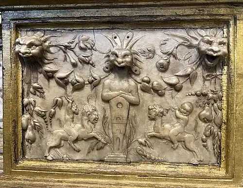 Figures grotesques au bas du retable en bois doré.