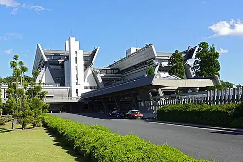 Un bâtiment moderne, en béton clair aux formes anguleuses.