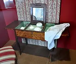 Une poudreuse, petit meuble apparenté à une coiffeuse.