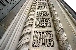 Le monogramme marial sur le montant central du portail.