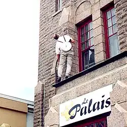 Performeur allant accrocher l'horloge.