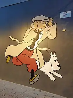 Fresque murale montrant Tintin vêtu d'une casquette courant à côté de Milou